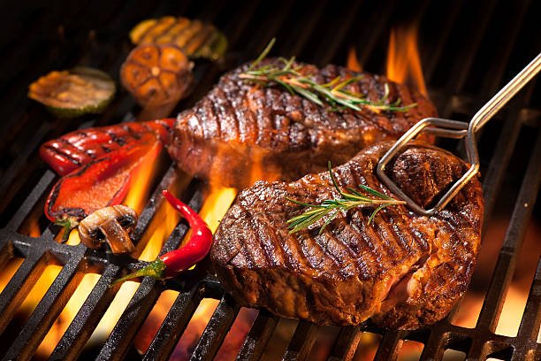 beef steaks on the grill with flames